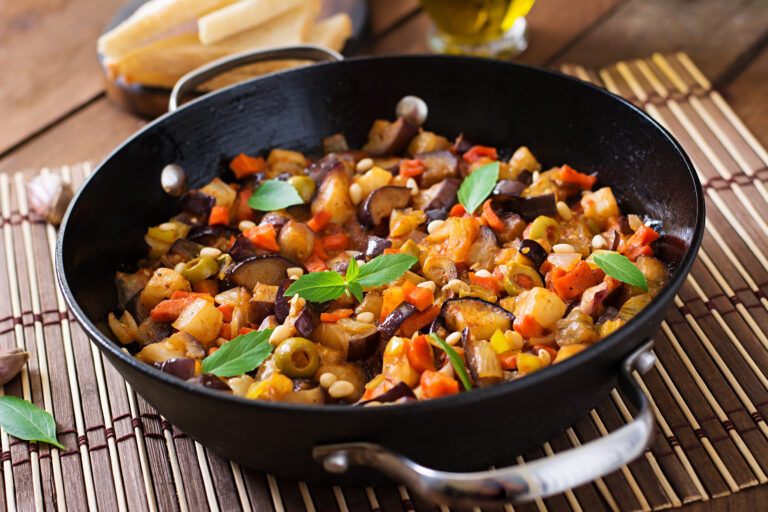 caponata-italiana-con-padella-su-un-tavolo-di-legno